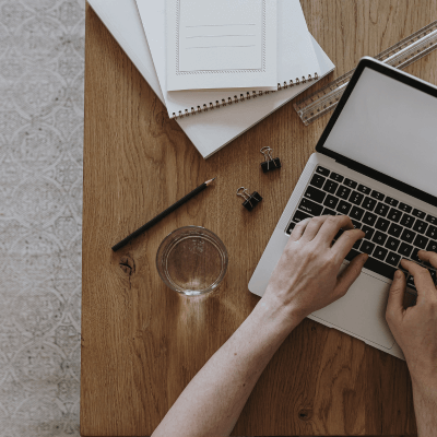 Trau dich! Deine GmbH-Gründung gegen alle Widrigkeiten || Kein Kapital, wenig Einkommen, trotz Schulden 5 Planung einer GmbH-Gründung trotz wenig Kapital – Arbeit mit Notizbuch und Laptop